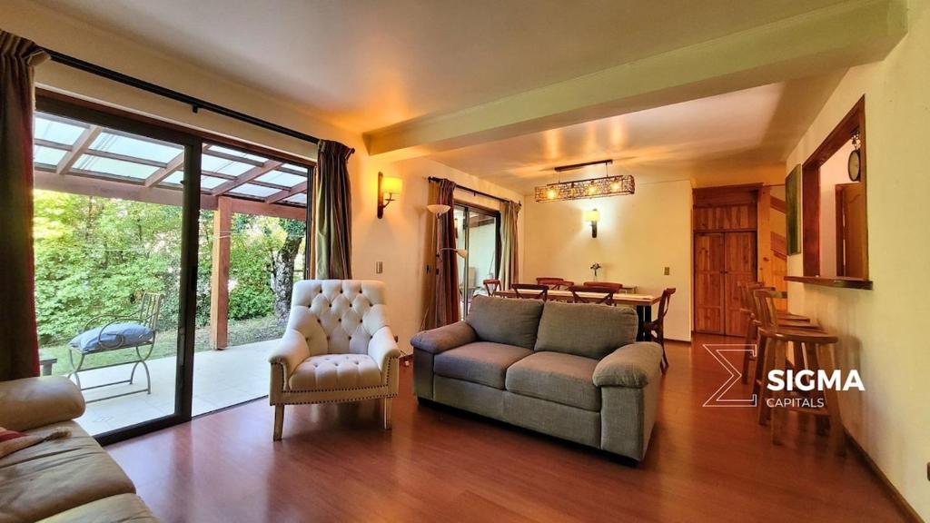 uma sala de estar com um sofá e uma mesa em Amplia Casa Familiar en Condominio Privado em Pucón