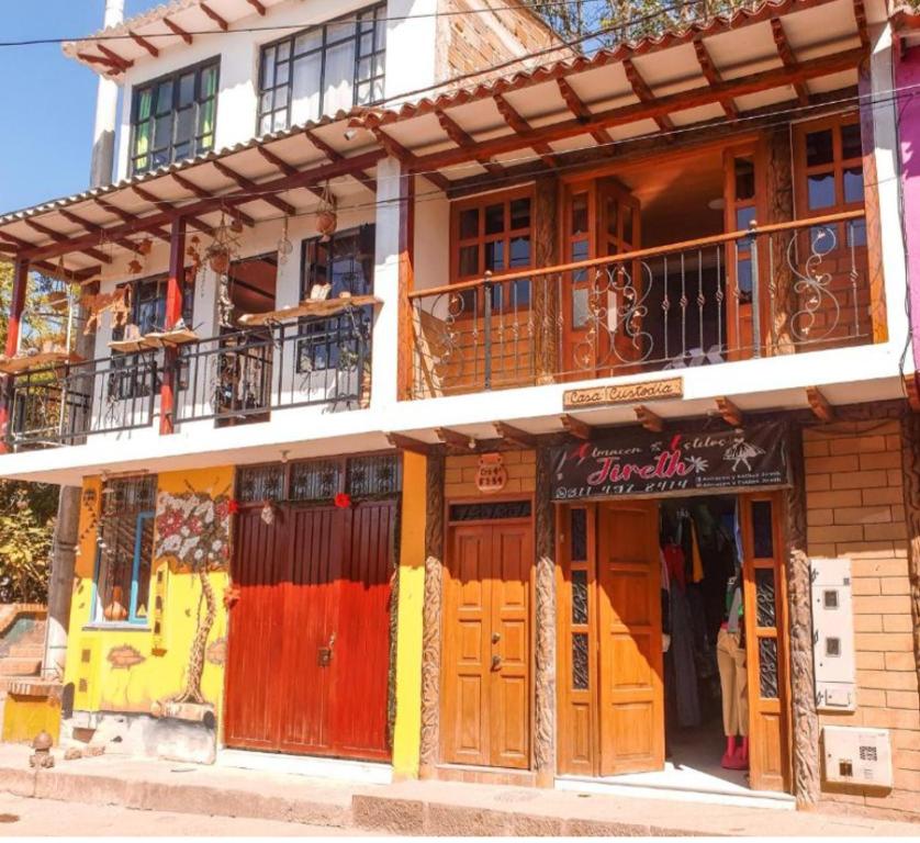un edificio con puertas de madera y balcón en El mirador Raquira centro, en Ráquira