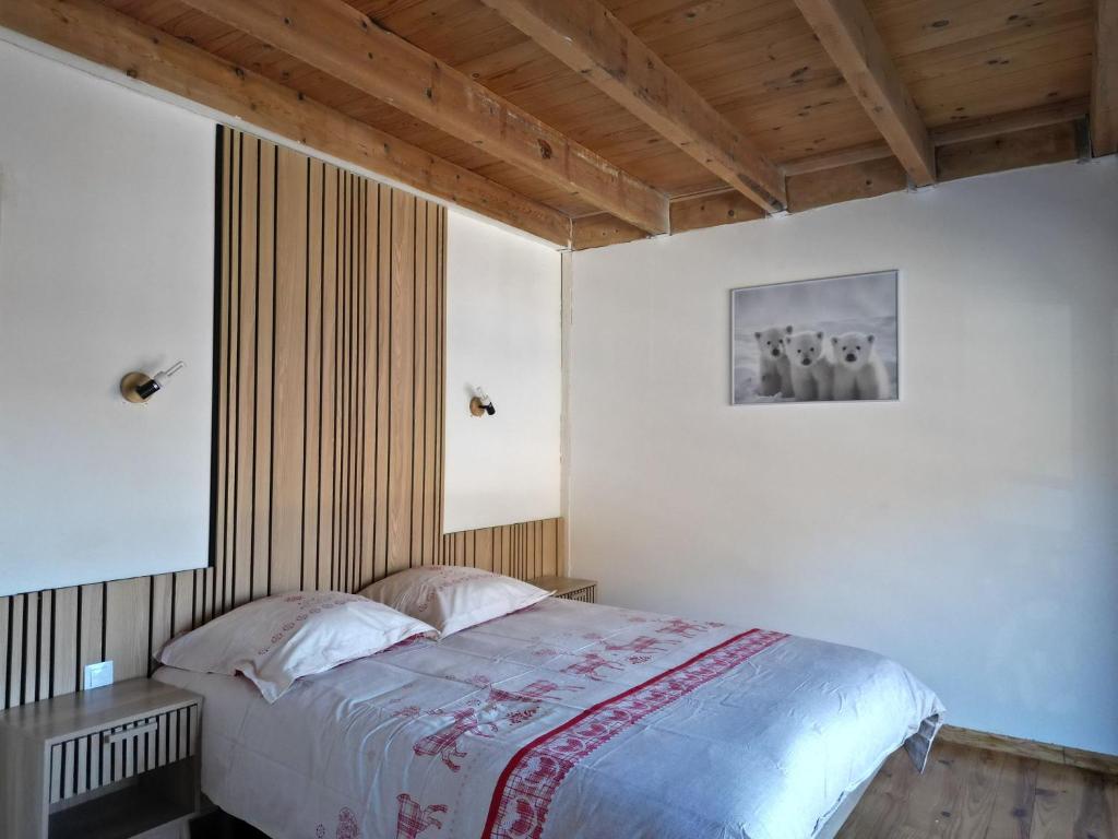 a bedroom with a bed and a picture on the wall at Chalet EGAT in Égat