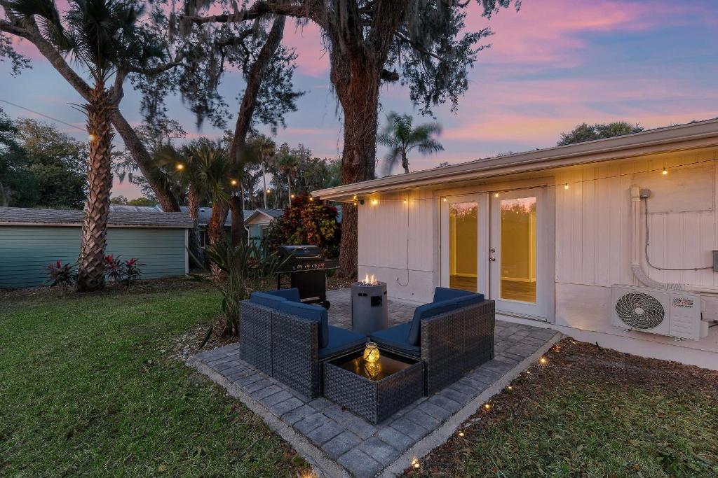 un patio trasero con una hoguera y una casa en Happy Ours, en New Smyrna Beach