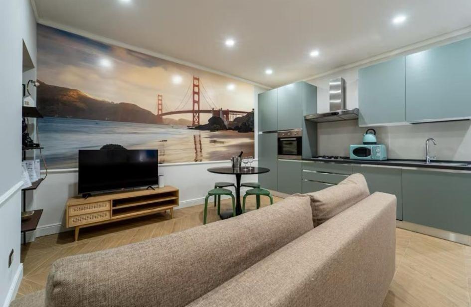 Thea- Duomo Centro storico في مونزا: غرفة معيشة مع أريكة وتلفزيون ومطبخ