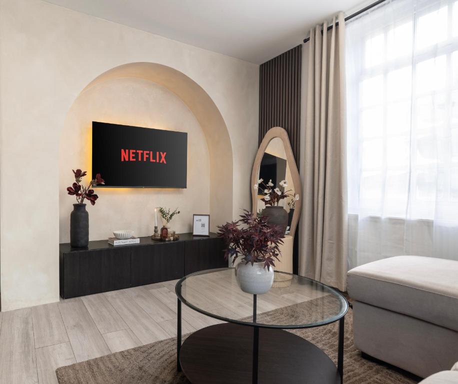 Una sala de estar con una mesa y un espejo. en New Modern 2 Bedroom Central Apt Greater Manchester, Sleeps 5, Near Airport with Great Transport Links, en Stockport