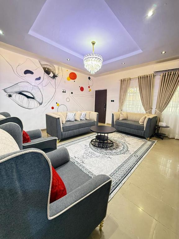 a living room with couches and a painting on the wall at Luxury Apartment in Abuja