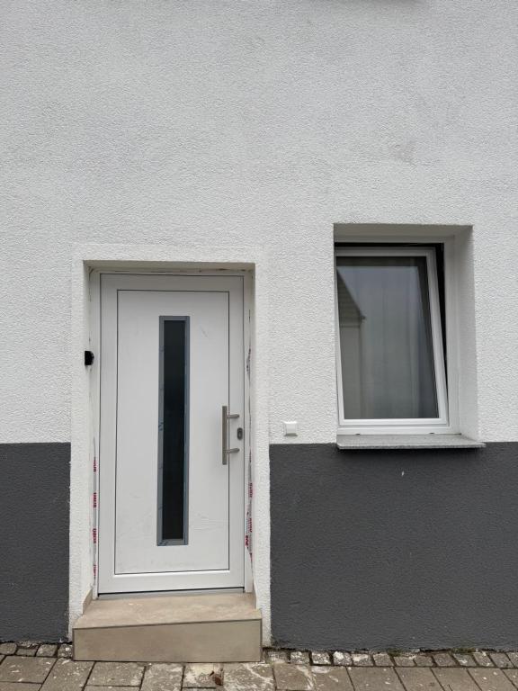 Comfort Apartment في Denkendorf: باب أبيض ونوافذ على مبنى