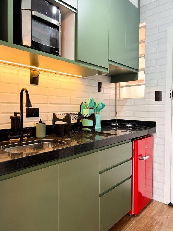 a kitchen with a sink and a red cabinet at AP Smart City Life Flat in Campinas