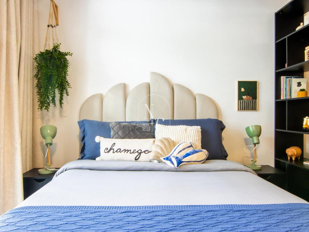 a bedroom with a bed with a large headboard at RioDowntown Hub by RNC Flats in Rio de Janeiro