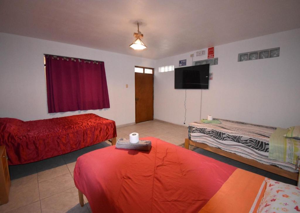 Una sala de estar con dos camas y un televisor. en The Chusay Home, en Abancay