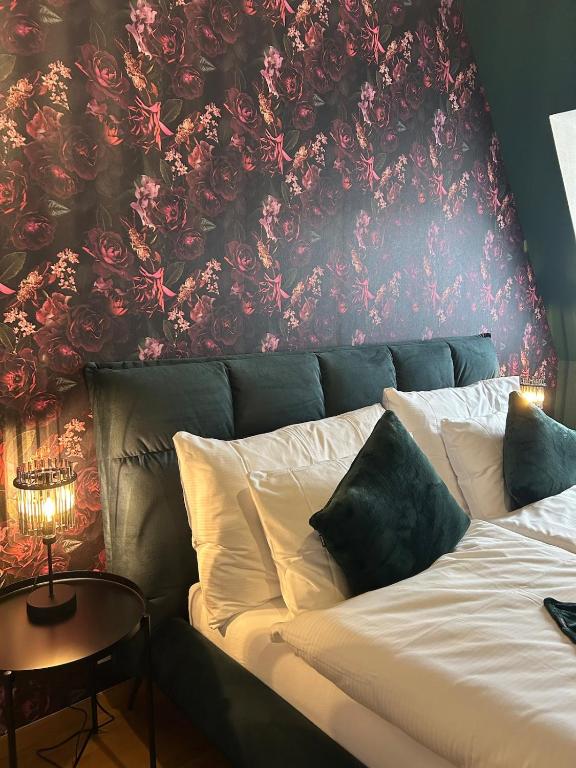 a bedroom with a bed with a floral wall at Maisonette am Bodensee - Parking - Hoher Komfort in Rorschach