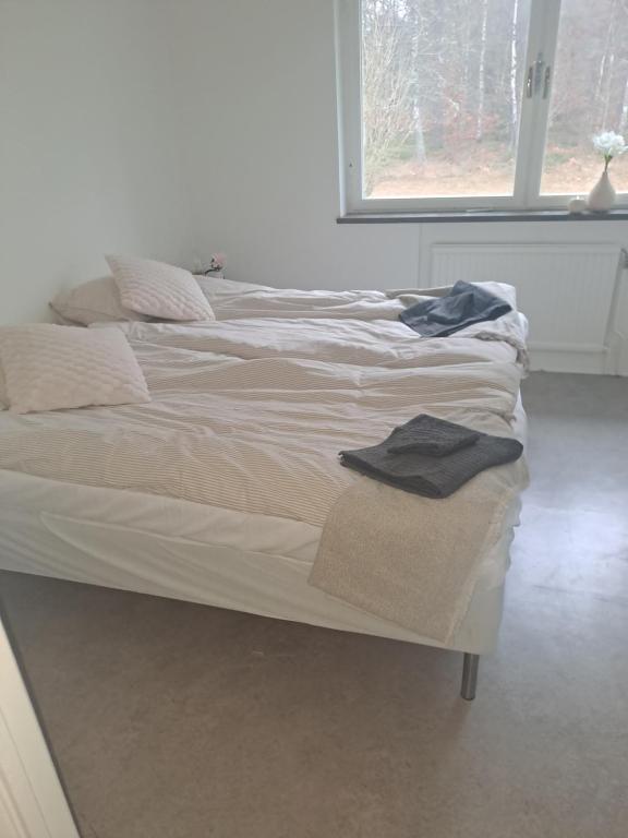 a white bed with towels on it in a bedroom at Selmas Pensionat in Vittsjö
