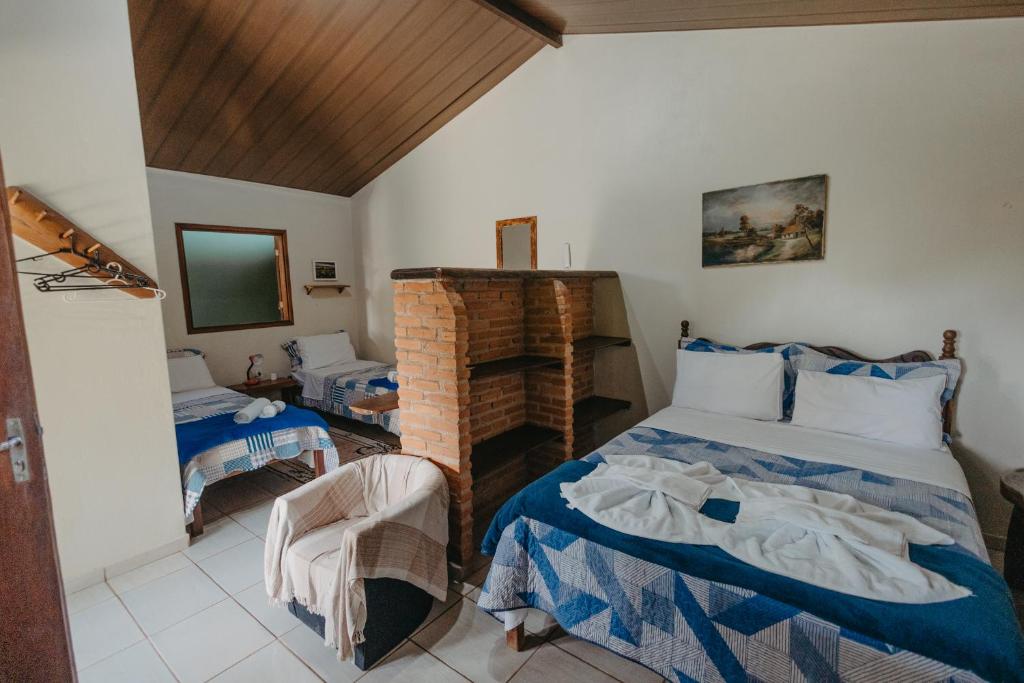 戈亚斯州上帕莱索Pousada Casa do Cerrado - Alto Paraíso de Goiás的卧室里有一张床和一把椅子