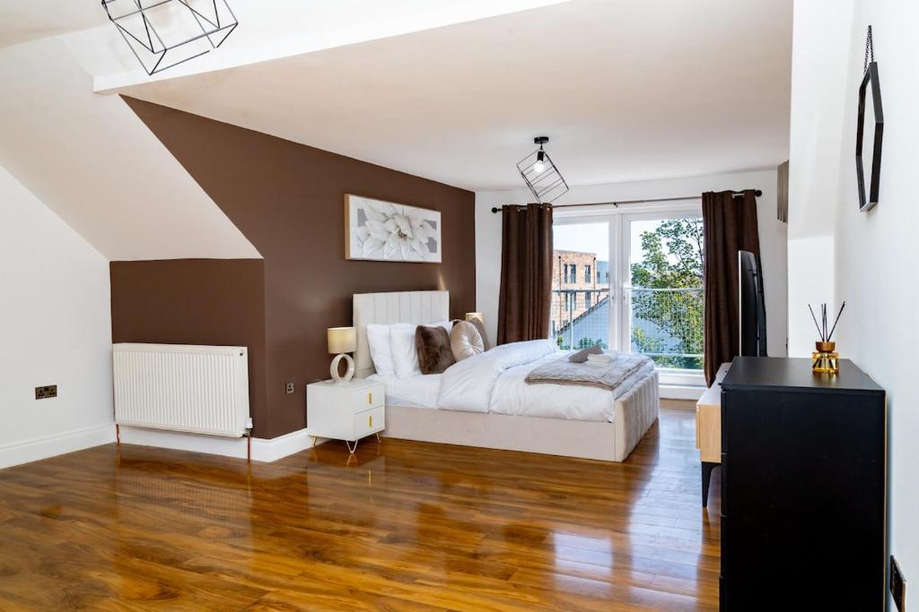 エディンバラにあるLuxury 5BD, Gym, Parking, Bus to Airport, Sleeps10のベッドと大きな窓のある寝室