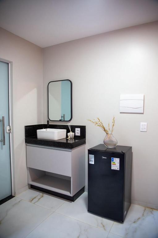 a bathroom with a sink and a mirror at Aloha flats in Marechal Deodoro