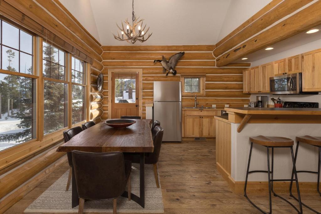 a kitchen with a table and a refrigerator at Powder Ridge Cabin - 9A Red Cloud in Big Sky