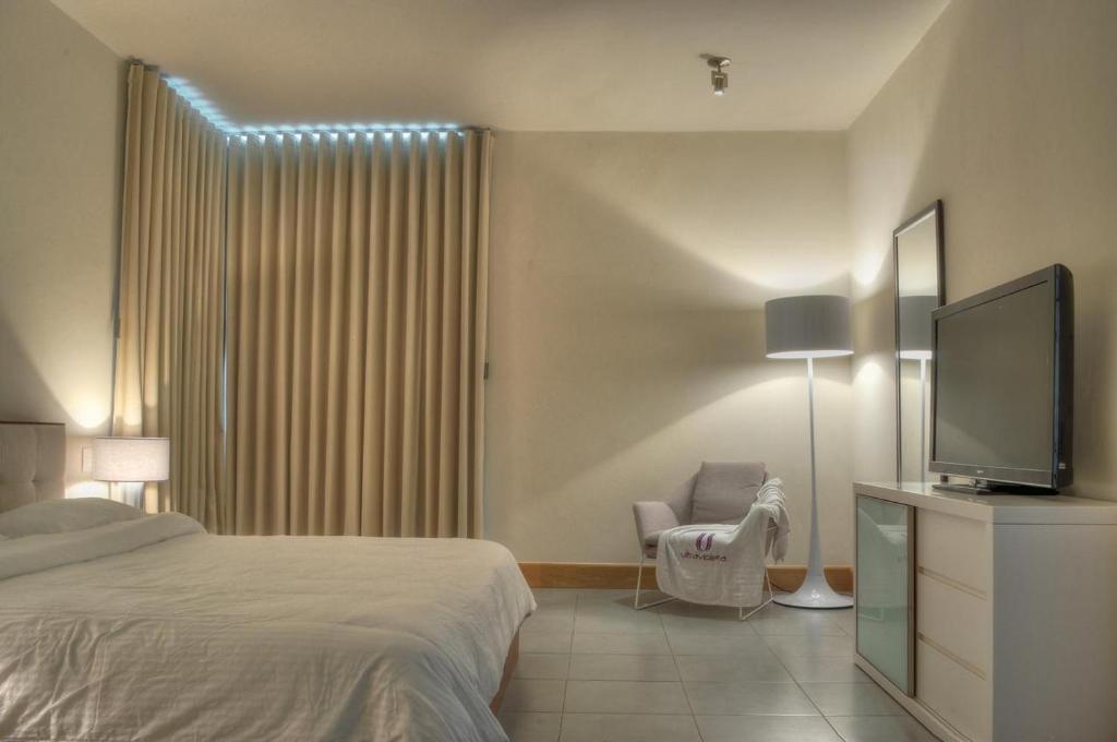 キャバレテにある2 Bedroom Apartmentのベッドと薄型テレビのある寝室