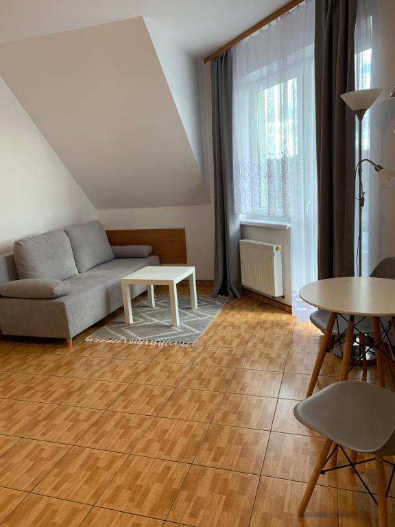 Pensjonat Melodia في بوبيروفو: غرفة معيشة بها أريكة وطاولة