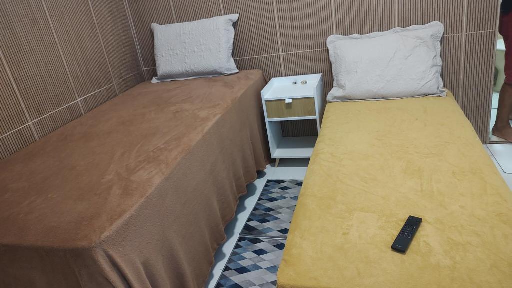 two beds sitting next to each other in a room at Suíte Aconchego na Casa 68 in Belém