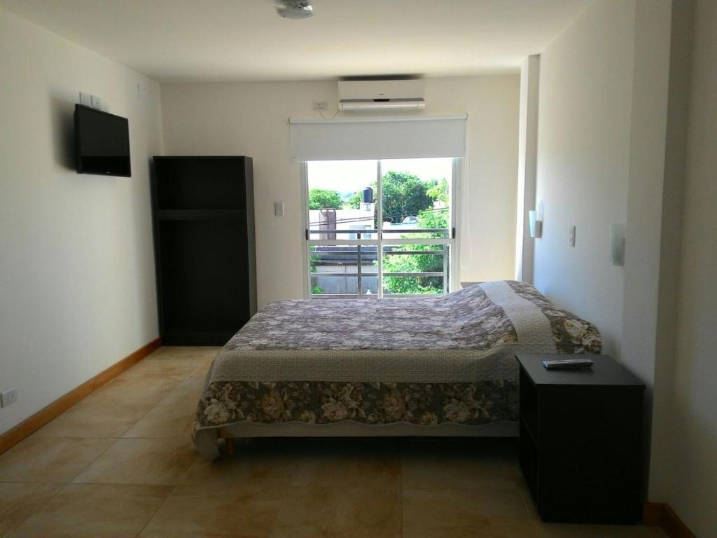 a bedroom with a bed and a large window at Apartamentos Don Bosco in Paso de los Libres