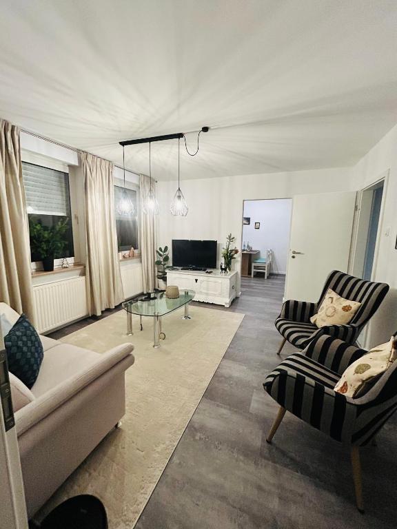a living room with a couch and chairs and a television at Ferienwohnung Paradies in Osnabrück