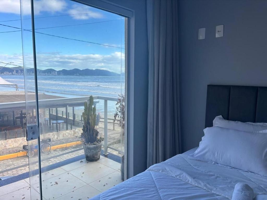 Un dormitorio con una cama y vista al mar. en Dúplex con impresionantes vistas al mar RAT002, en Perequê