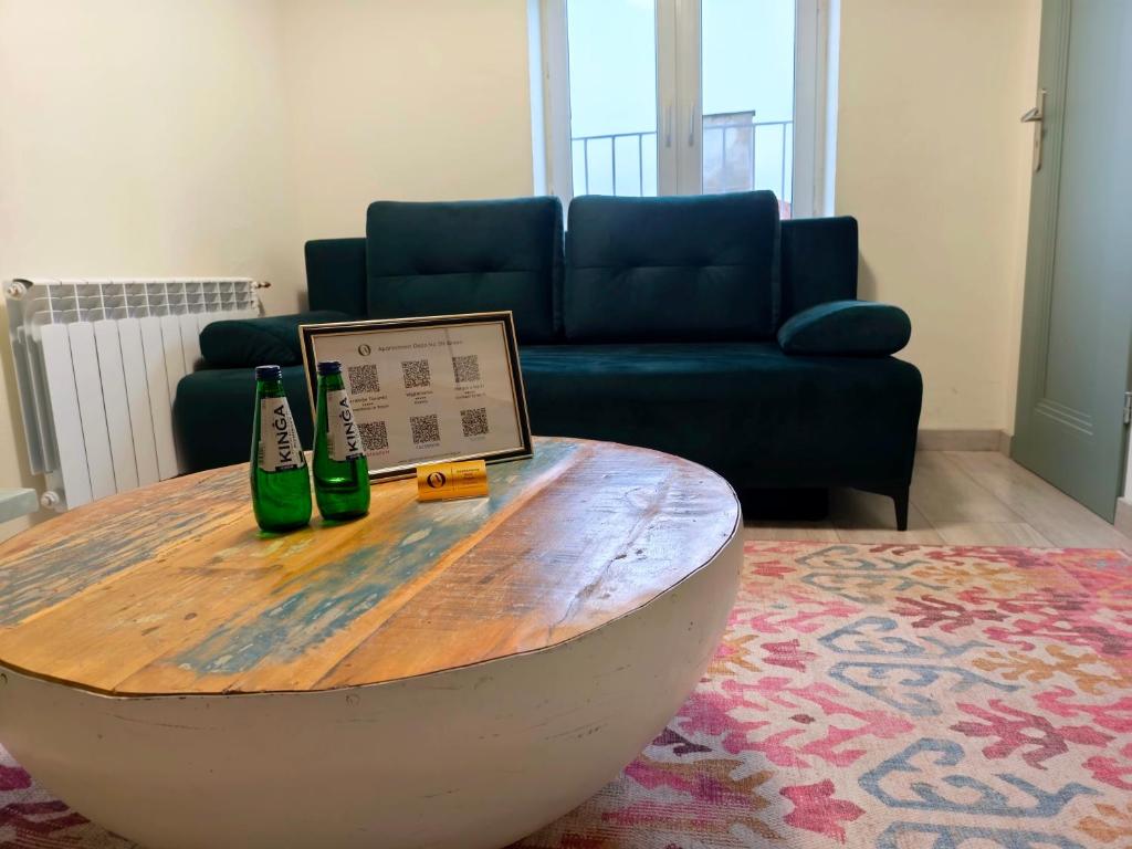 un tavolino da caffè con due bottiglie e un computer portatile sopra di Apartament Oaza No 511 Green a Toruń