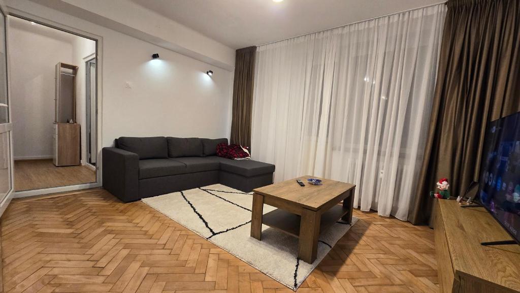 a living room with a couch and a table at Shakespeare Central Apartment in Craiova