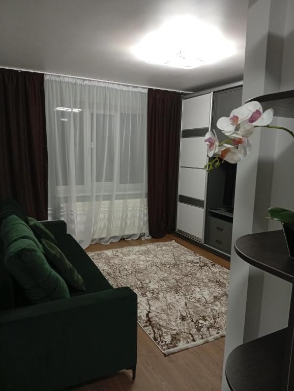 a living room with a green couch and a rug at Dolce Vita in Ternopil