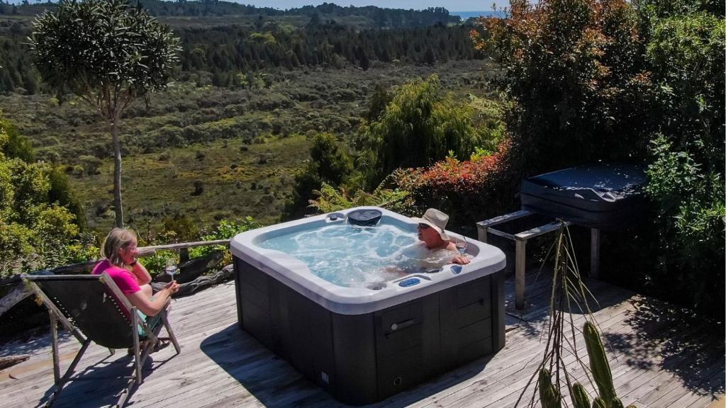 Birds Ferry Lodge Luxury B&B في ويستبورت: امرأة تجلس على كرسي في حوض استحمام ساخن