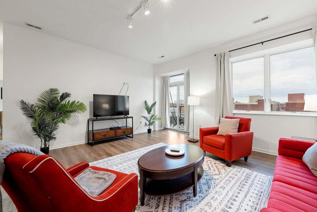 a living room with red furniture and a tv at Spacious 3BR Urban Getaway w Gym in Chicago