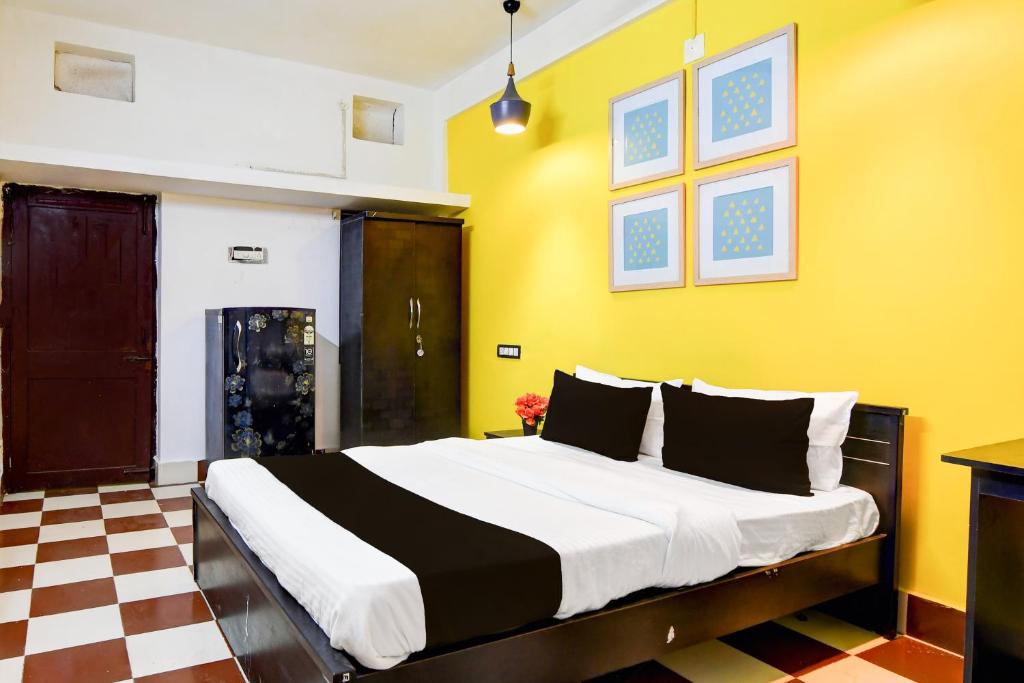 Hotel O Rasulgarh Square Bus Stop Formerly Hotel Rose Inn في Bālianta: غرفة نوم بسرير كبير وبجدران صفراء