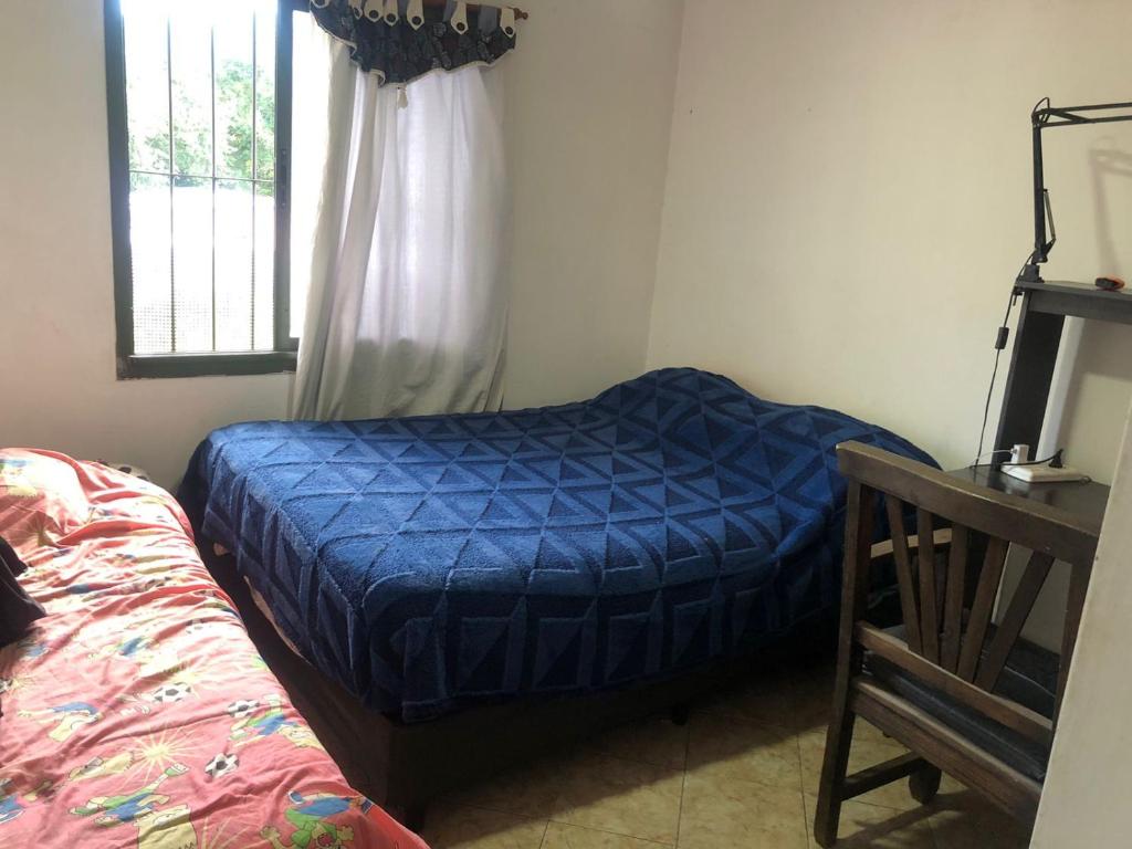 a bedroom with a blue bed and a window at Carcano in Villa Carlos Paz