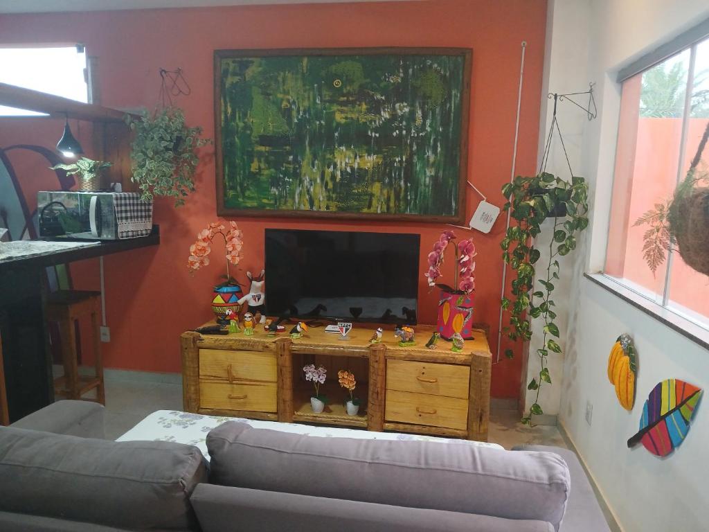 a living room with a couch and a flat screen tv at Casa de praia Laranja a beira-mar in Ilhéus