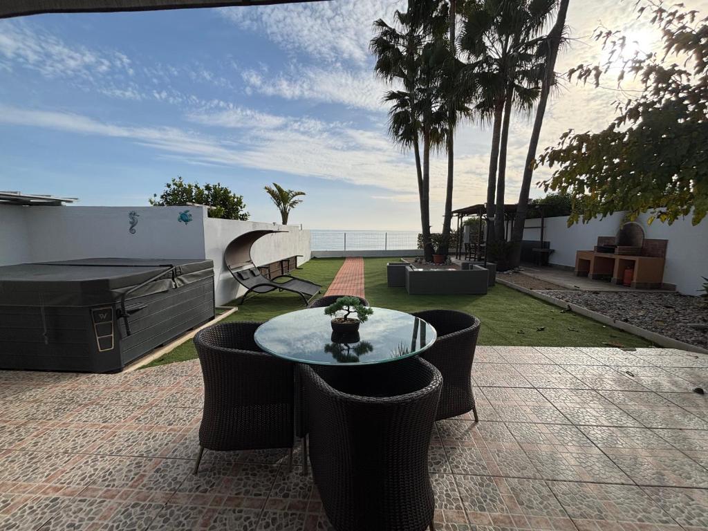 een terras met een tafel en stoelen en de oceaan bij CHALET directo al MAR in Benicarló