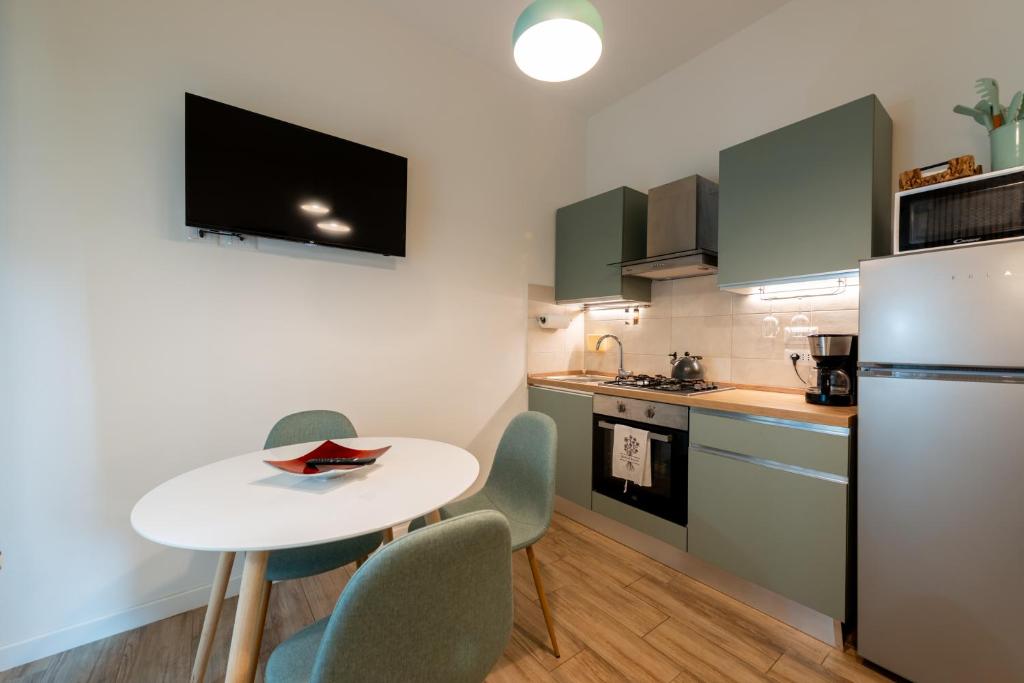 a kitchen with a table and chairs and a refrigerator at APARTMENT BONCIARI PERUGIA Comodo e moderno bilocale con posto auto gratuito e self check in in Perugia