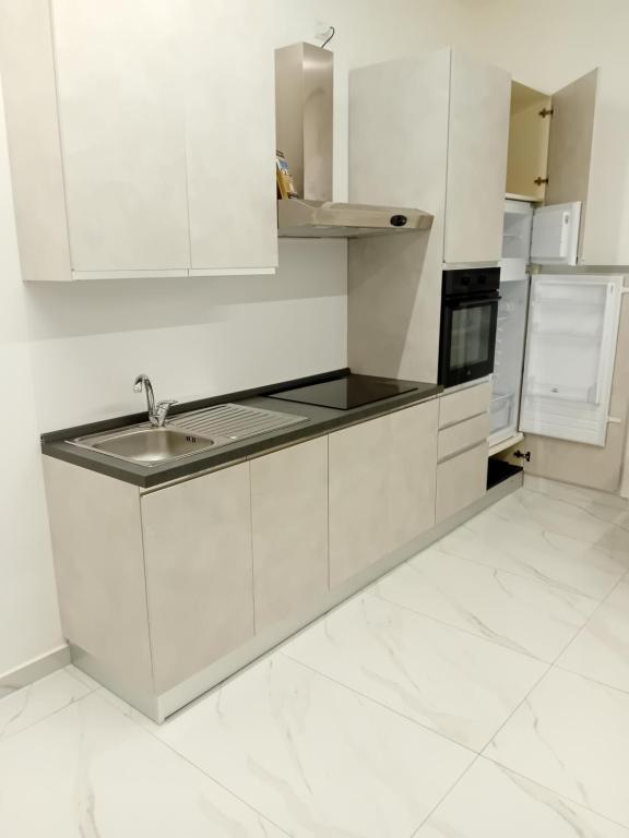 Il Don Giovanni Room في بارليتا: مطبخ بخزائن بيضاء ومغسلة