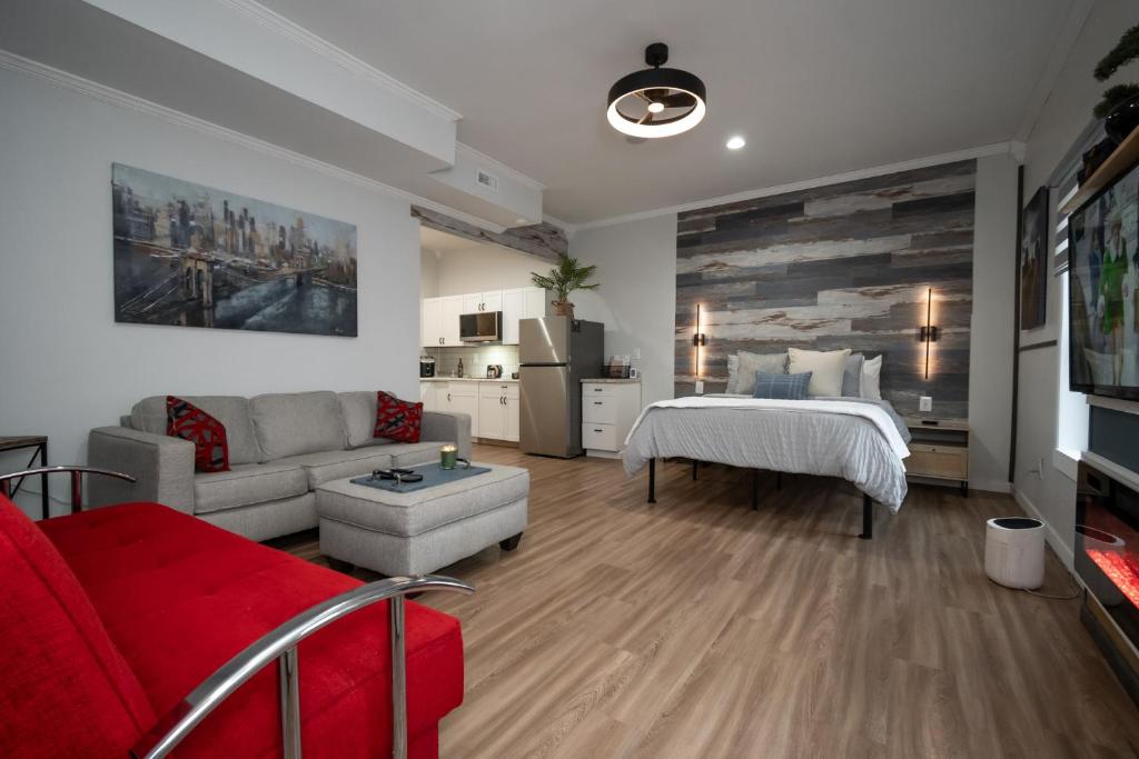 阿森斯Charming Hideaway 1 BR APT 10 min to UGA的客厅里有一张红色的沙发和一张床