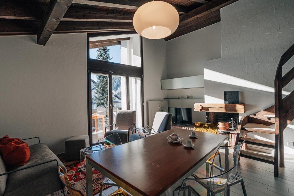 ein Wohnzimmer mit einem Holztisch und einer Küche in der Unterkunft Casa Laret 6-12 in Laax-Murschetg
