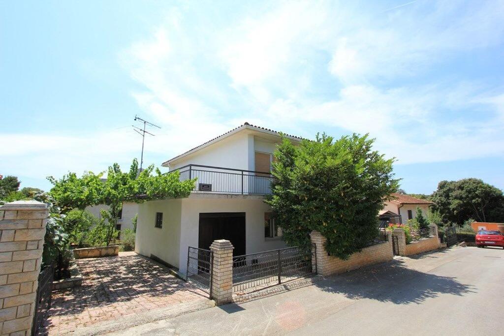 a white house with a fence in front of it at House Paulina in Banjole