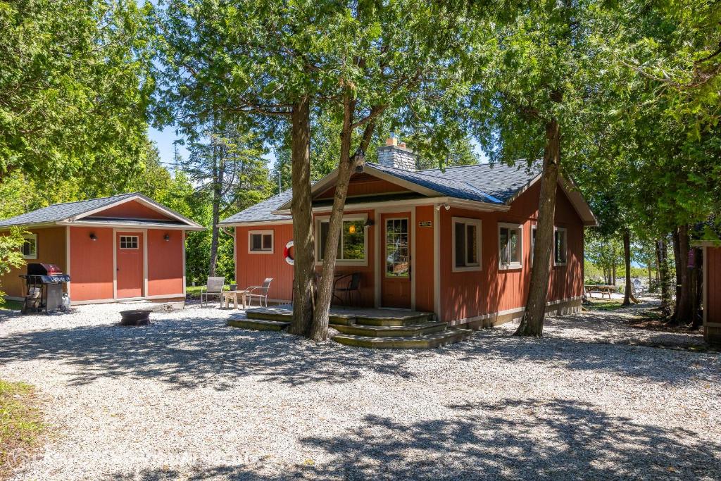 a small house with trees in front of it at Breezy Woods - Tobermory Waterfront in Tobermory