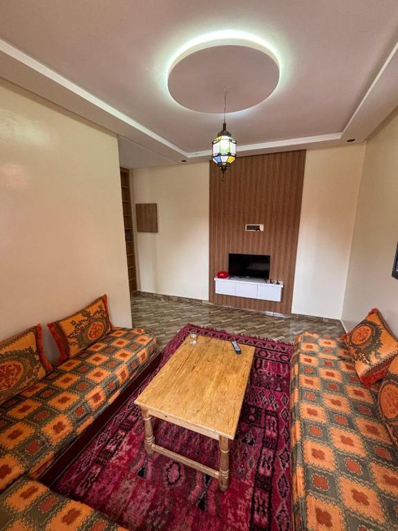 een woonkamer met een bank en een tafel bij Breeze surf lodge in Tamraght Ouzdar