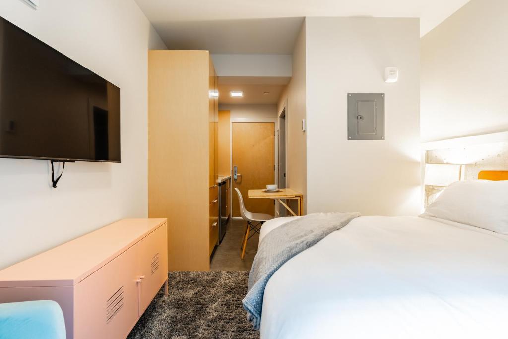 a hotel room with a bed and a flat screen tv at Downtown Edge-Stylish Studio Near Hospitals & Downtown-03 in Seattle