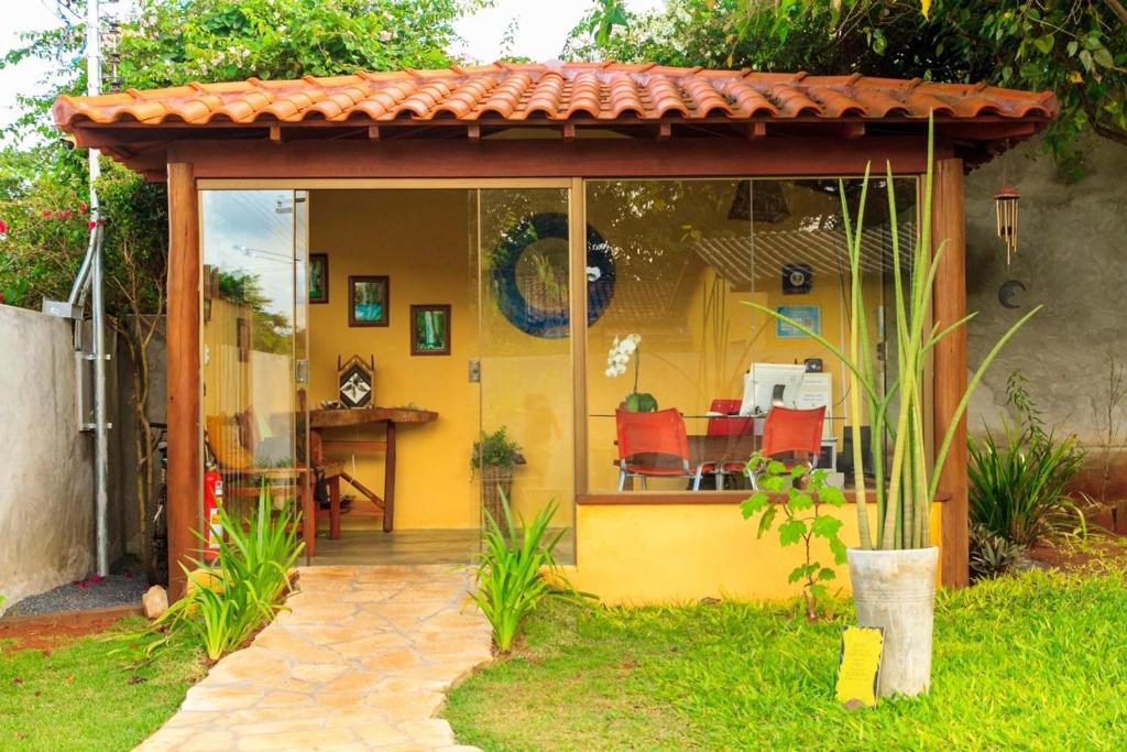 ein gelbes Haus mit einer Terrasse und einem Tisch in der Unterkunft Recanto caracol in Alto Paraíso de Goiás