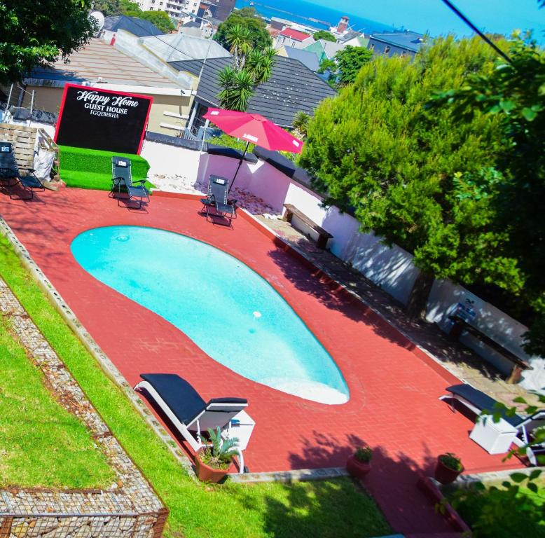 una vista aérea de una piscina con sillas alrededor en HAPPY HOME Guest house, en Gqeberha