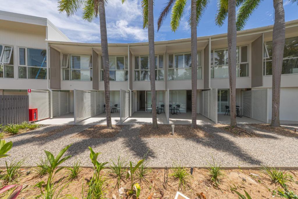una vista esterna di un edificio con palme di Picnic Bay Hotel a Picnic Bay