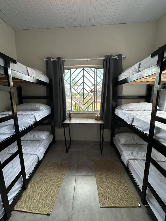 een kamer met 3 stapelbedden en een raam bij Zig Zag Hostel in Itacaré