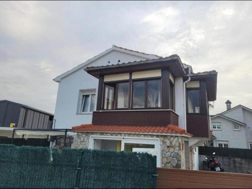 una casa bianca con una recinzione davanti di Alojamiento tresdiva a El Astillero