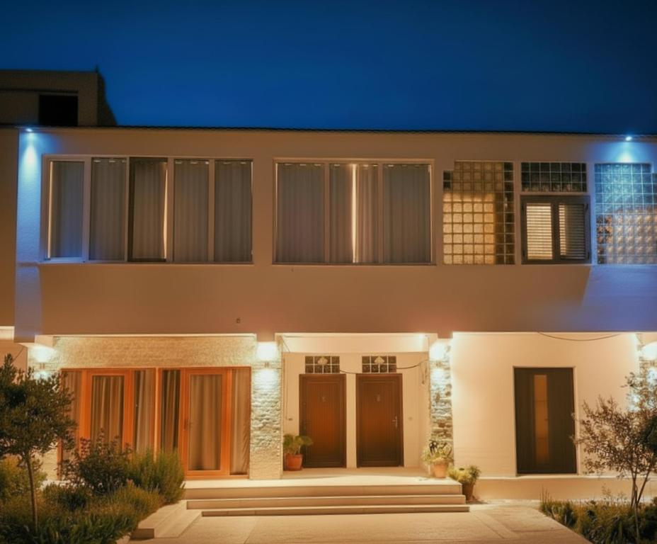 a house with a lit up facade at night at Pomegranates & Olives Guesthouse in Durrës