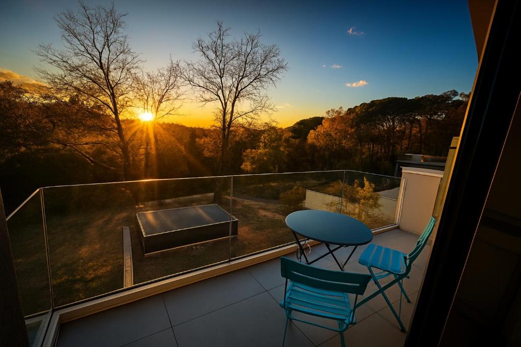 un balcón con una mesa y 2 sillas y la puesta de sol en Incroyable vue, en Bouliac