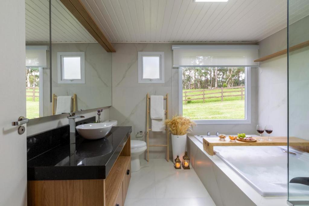 a bathroom with a large tub and a sink at Condado de Urubici - Cabana in Urubici