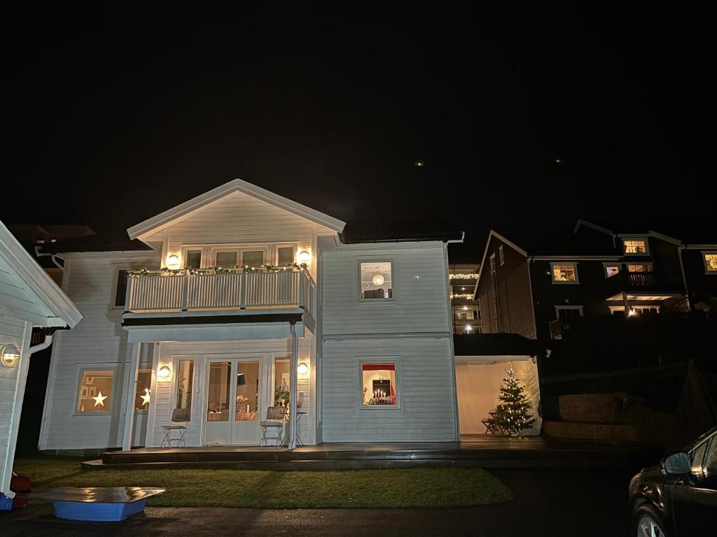 una casa bianca con balcone di notte di Klebersteinsveien 6 a Holmestrand