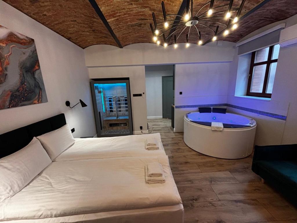 a bedroom with a large bed and a tub at Rybaki Sauna & Jacuzzi Apartment in Poznań